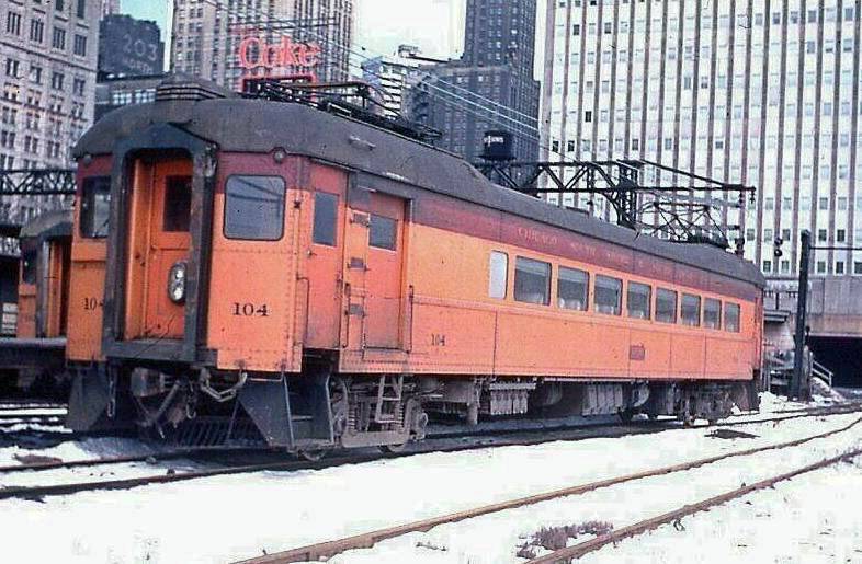 PHOTO - CHICAGO - RANDOLPH STREET STATION - CHICAGO SOUTH SHORE AND SOUTH BEND COMMUTER TRAIN - SNOW ON GROUND - PRUDENTIAL BUILDING - 1964